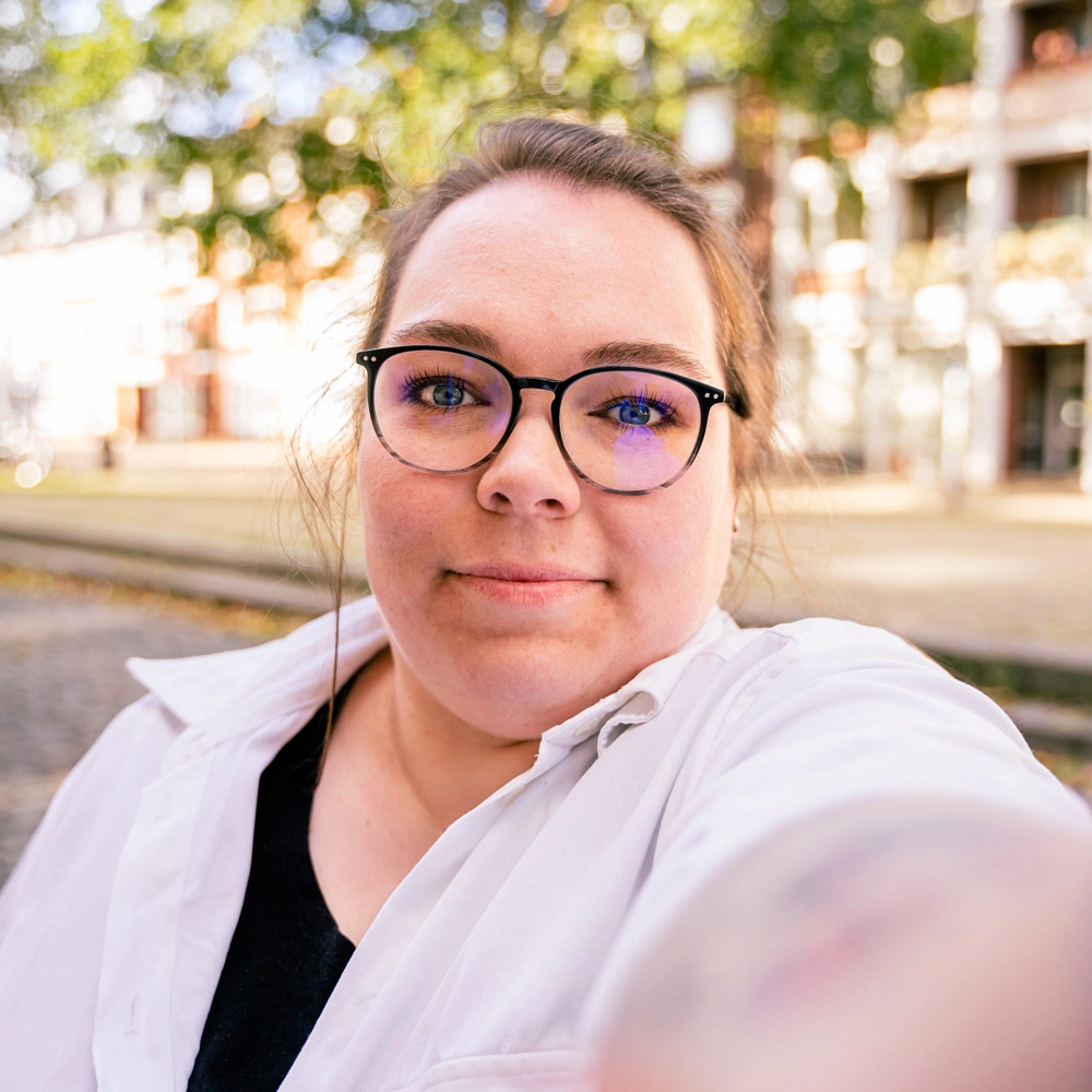 Profilbild von Texterin Juliane Büscher, lächelnd in einem Selfie-Stil Foto