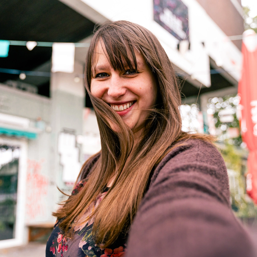 Profilbild von Content-Strategin Sina Schneider, lächelnd in einem Selfie-Stil Foto